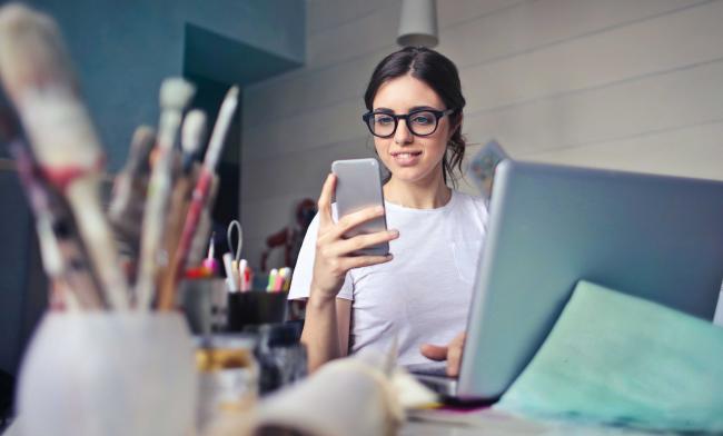 Una mujer creativa se registra con meetyoo en línea en el teléfono móvil