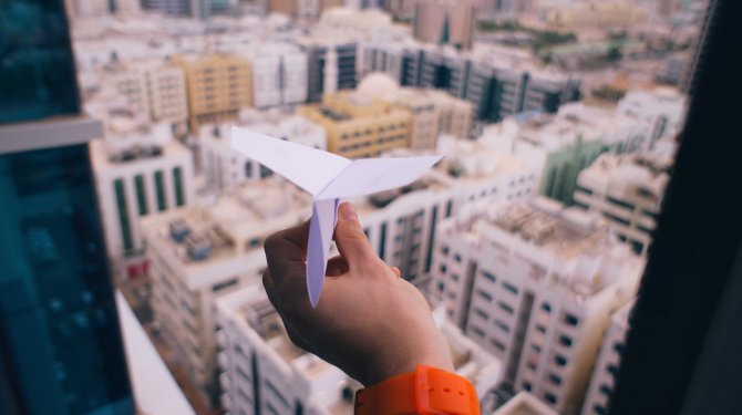 Avión de papel sobre casas