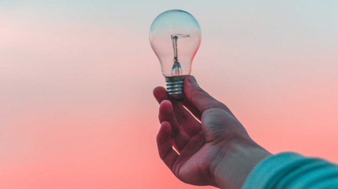 Hand holding a light bulb as a symbol of innovation