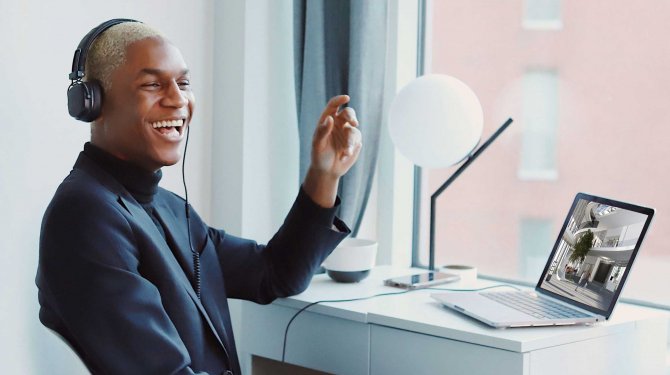 Happy person watching a virtual trade fair on a laptop