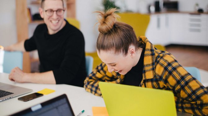 Two smiling people in a meeting